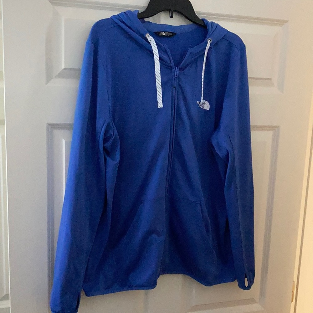 Lightweight North Face zip up jacket with thumb holes and a hood.